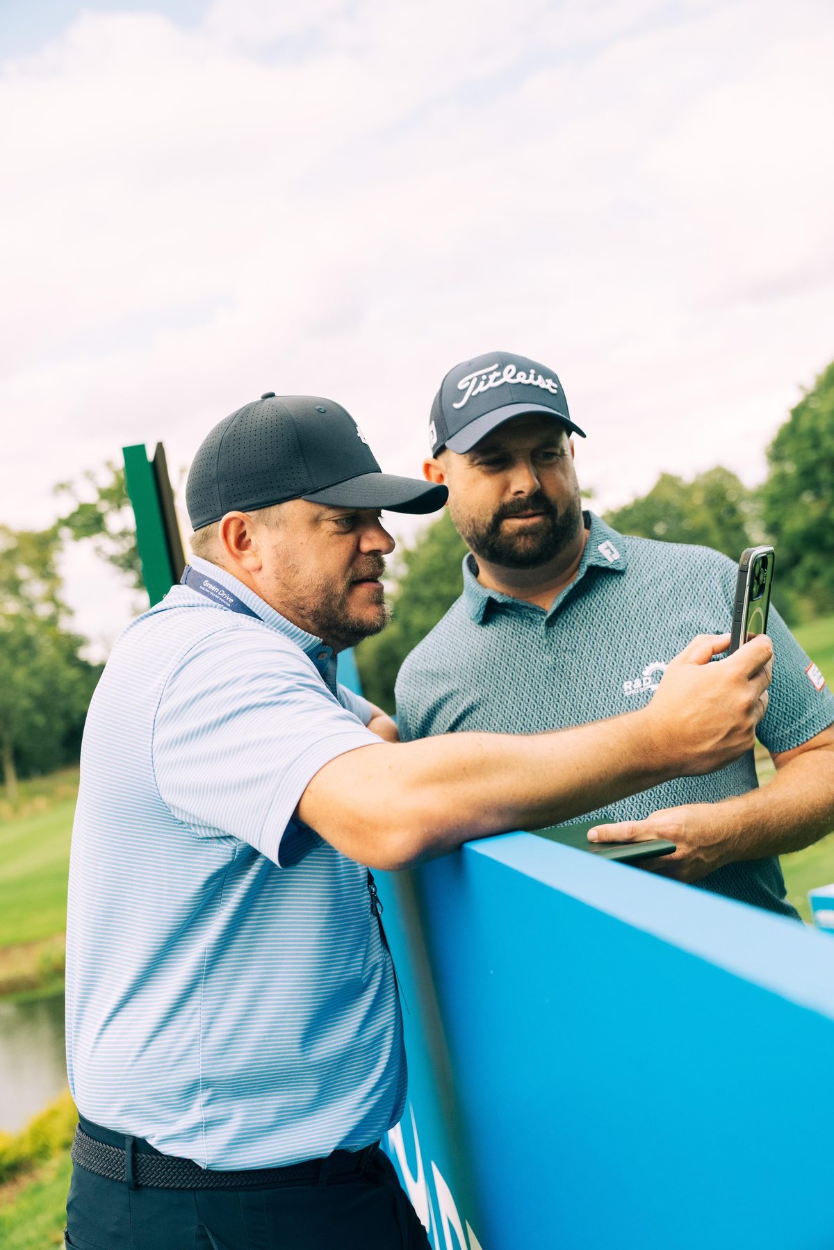 Coach reviewing a player's performance on a phone at a tour event